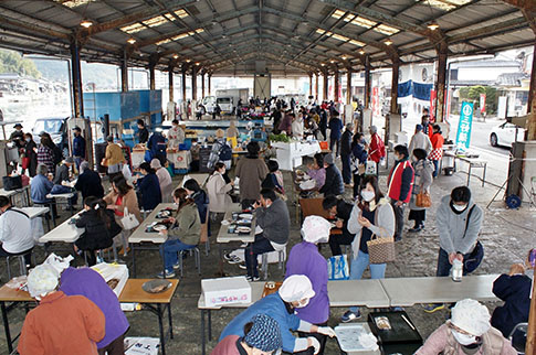 市場で朝ごはんを食べる人々の様子の写真