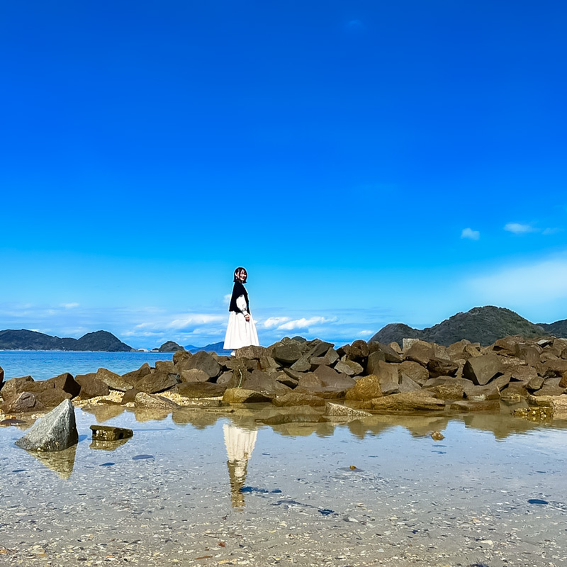 周防大島の岩礁に立つフォトランナーの写真