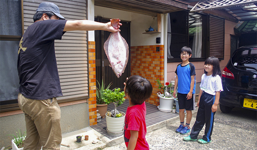 釣った魚をお裾分けする写真