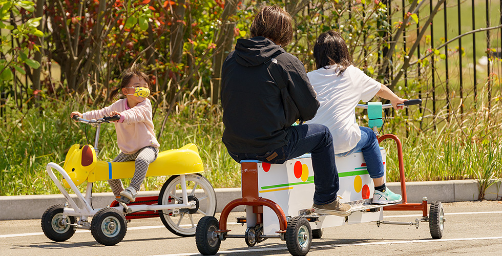 「おもしろ自転車」で遊ぶ親子連れの様子の写真