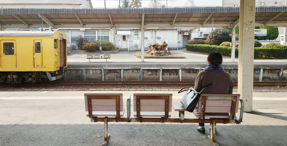 宇部新川駅のホームのベンチに座る体験者の写真