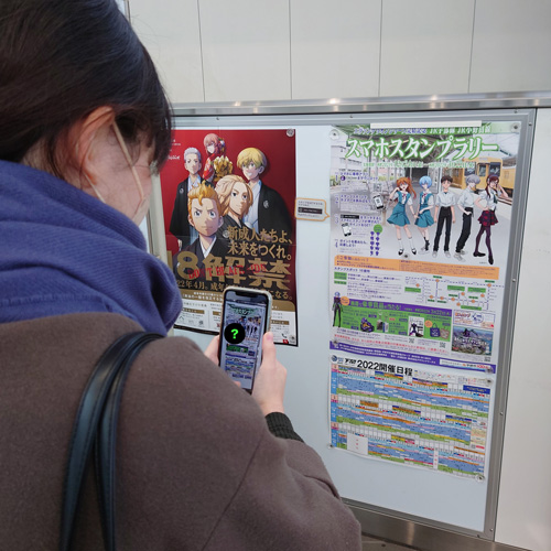 スタンプラリーのポスターを発見した体験者の様子の写真