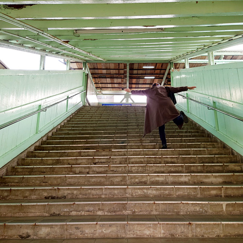 宇部新川駅の跨線橋の階段を上る体験者の写真