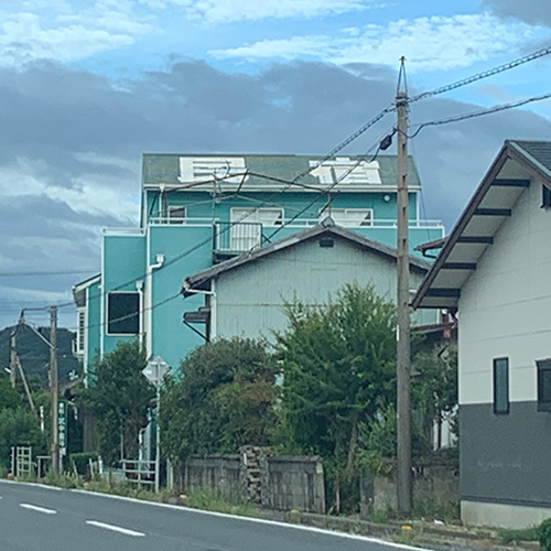 道路から見える「民宿」と書かれた屋根の写真