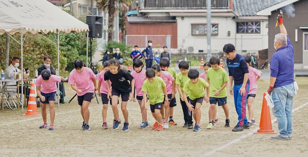 油谷繁さんと走る子どもたちの写真