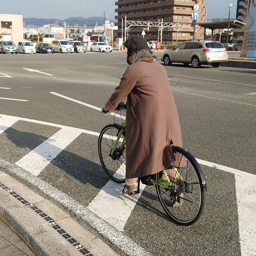 クロスバイクに乗り込む様子の写真